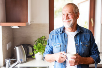 Photo of an older person stood in a kitchen