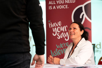 Photo of someone sat at a table in front of a Tenant Voice banner