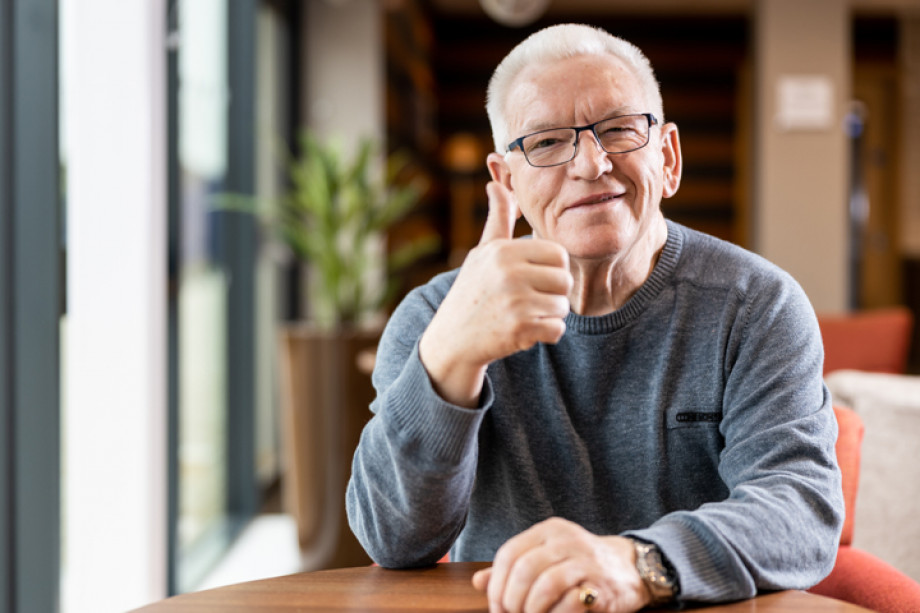 Photo of a person sat down giving a thumbs up