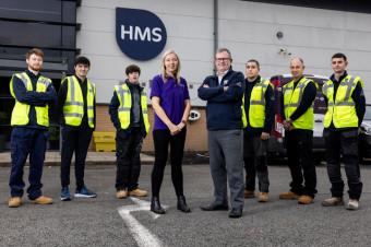 Photo of a group of people stood in front of a warehouse