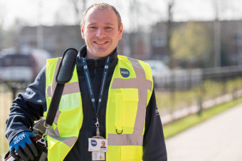 Photo of a HMS operative outdoors, smiling at the camera