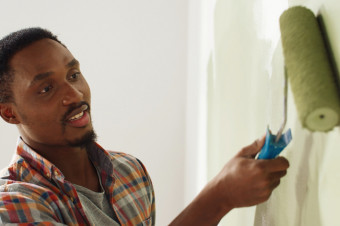 Photo showing someone painting a wall using a roller