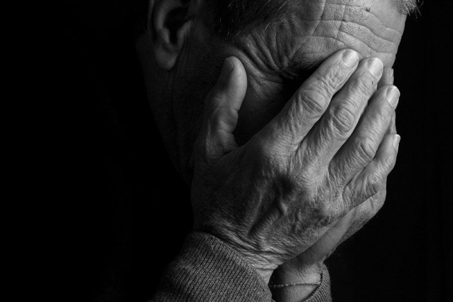 Black and white photo of someone with their head in their hands