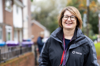 Photo of someone stood outdoors smiling at the camera